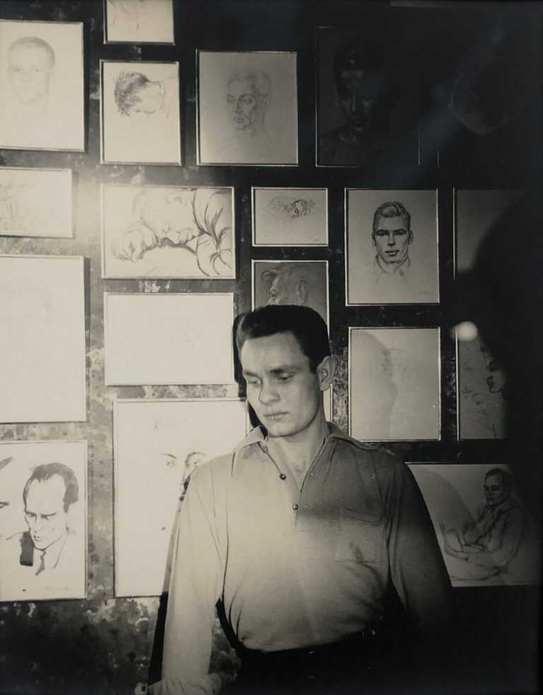 Photograph by George Platt Lynes: [Chuck Howard Standing in front of a Portrait Wall], available at Childs Gallery, Boston